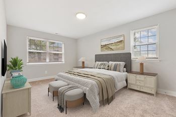 A bedroom with a bed and two windows